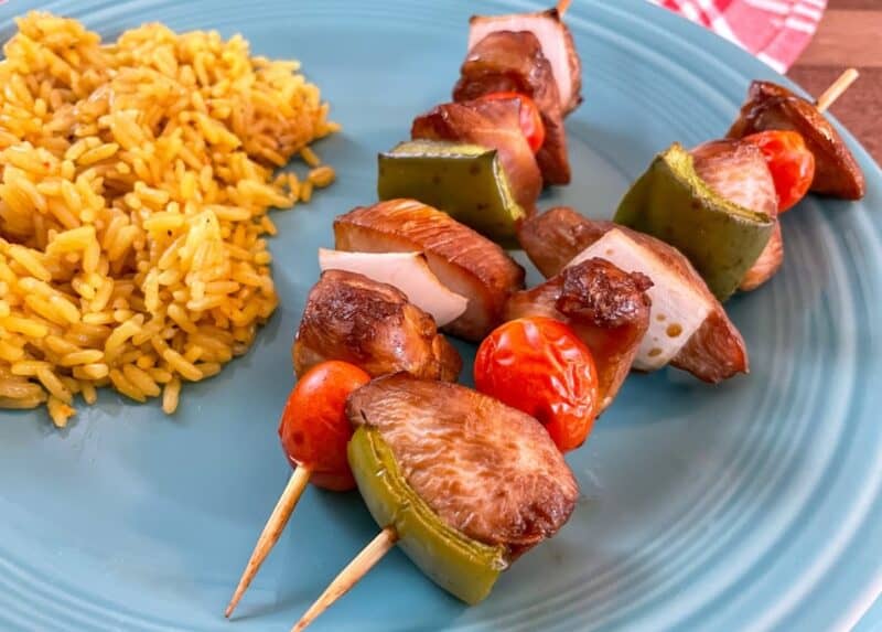 chicken kabobs on plate with rice.