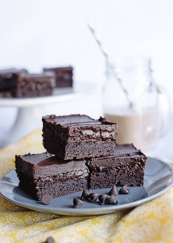 Plate of three stacked triple chocolate brownies.