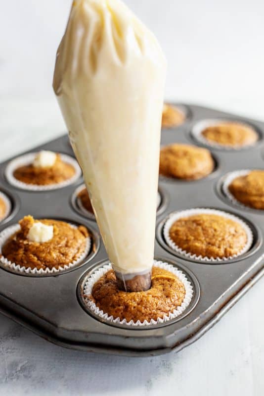 Pipe the cream cheese frosting into each pumpkin spice cupcake.