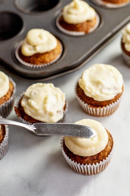 Spread cream cheese frosting over the top of each cupcake.