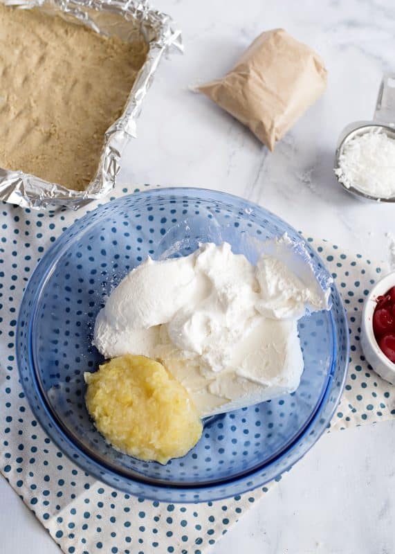 Beat together cream cheese, half of the whipped topping, powdered sugar, and drained pineapple.