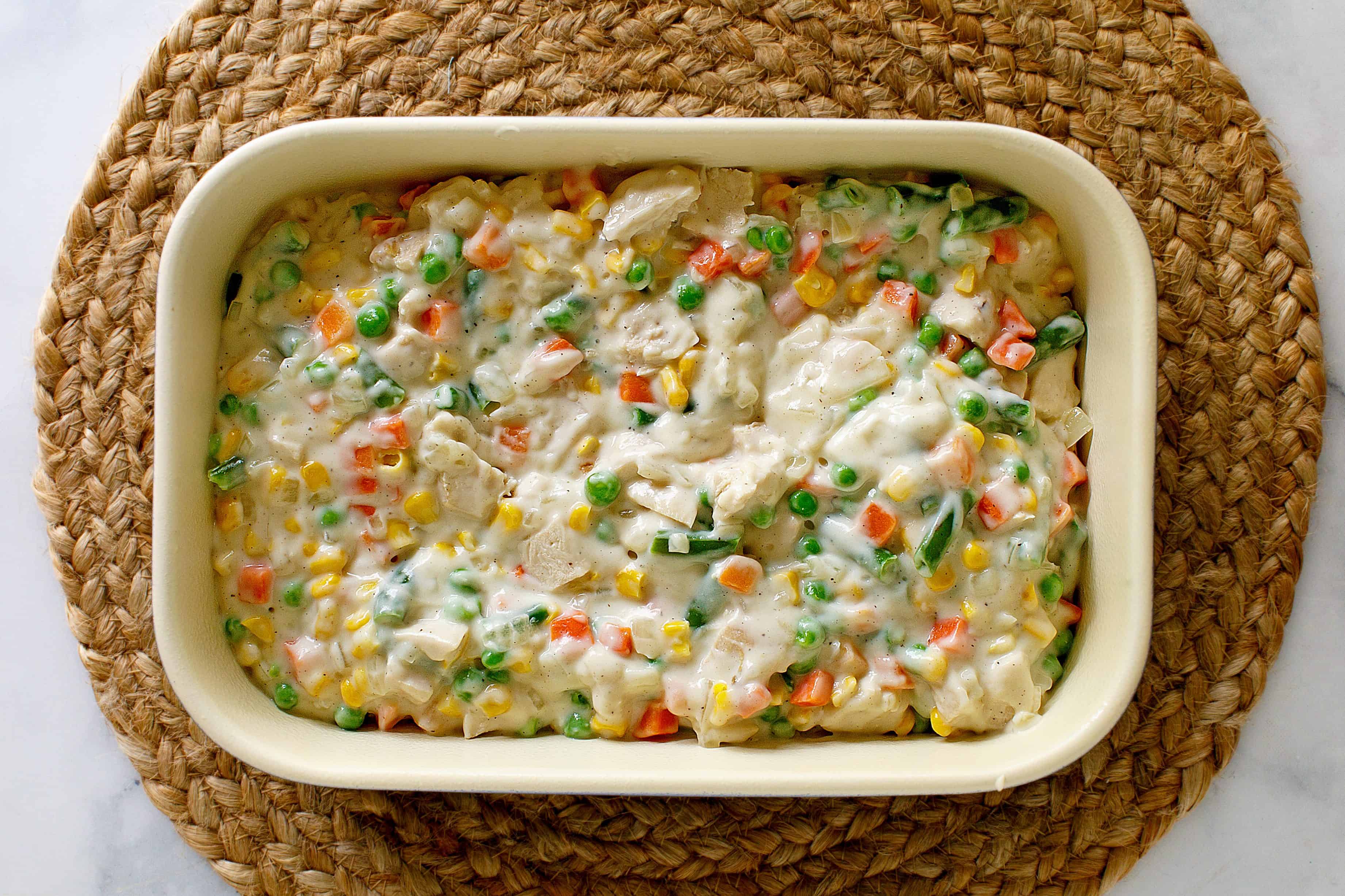 Chicken pot pie filling in a baking dish.