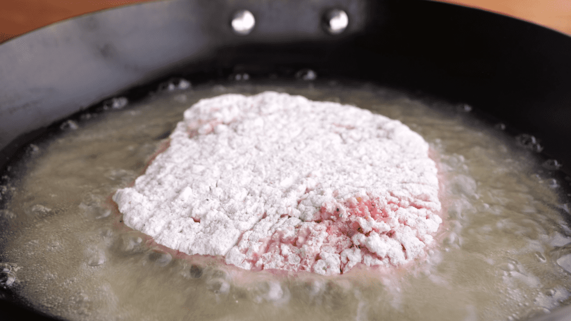 Placed breaded steak in skillet.