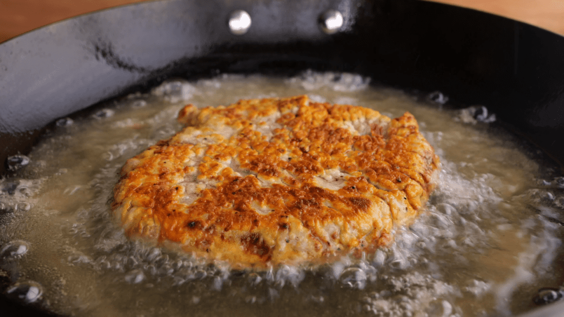 Once golden brown, flip the chicken fried steak and cook on the other side.