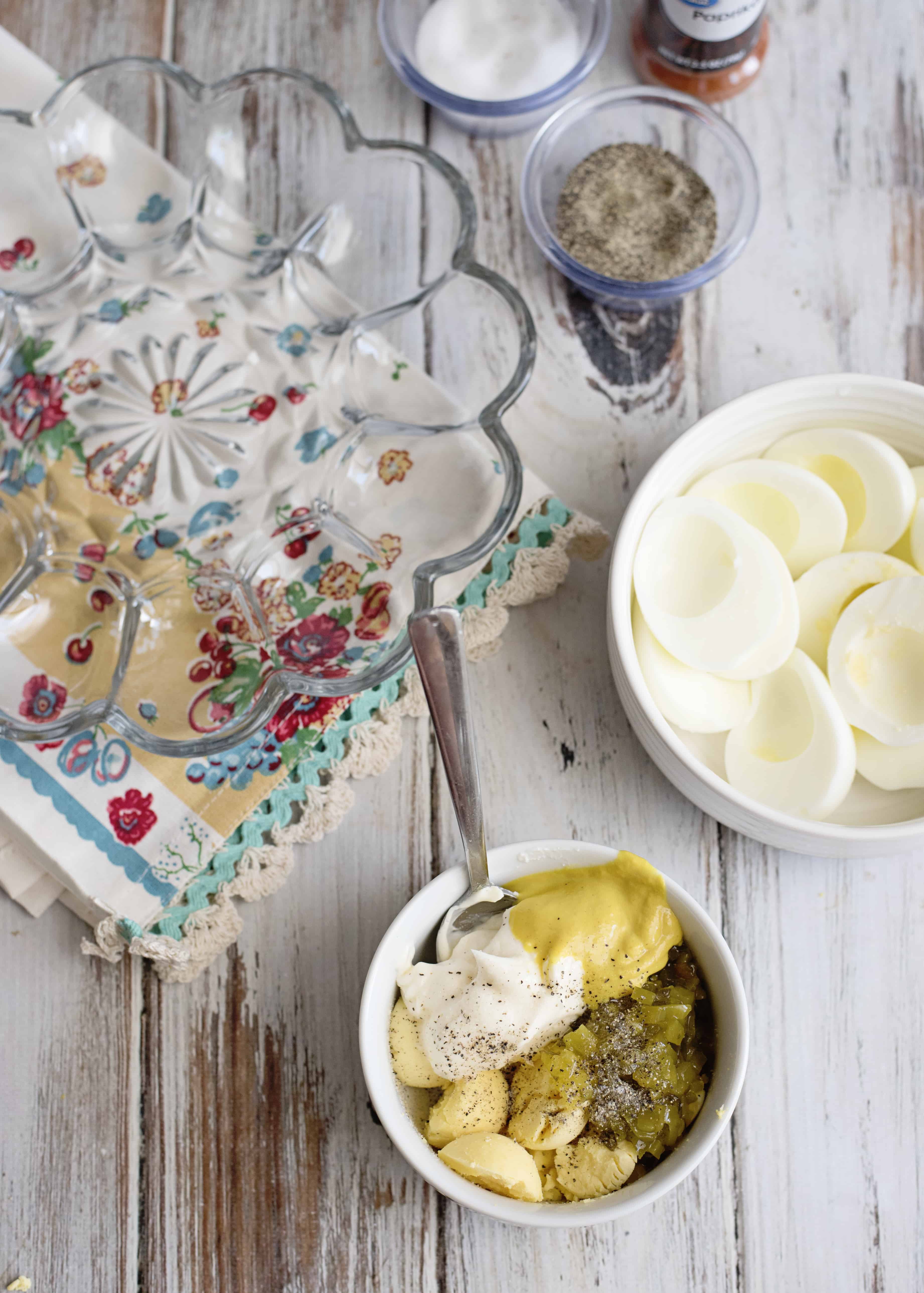 Egg white halves with yolks removed and a bowl of filling ingredients