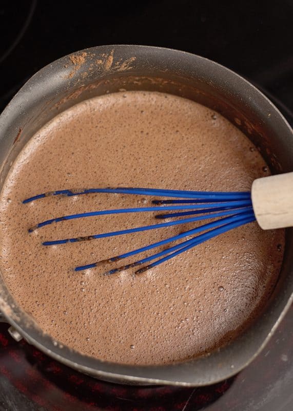 Whisk chocolate pudding on stovetop.