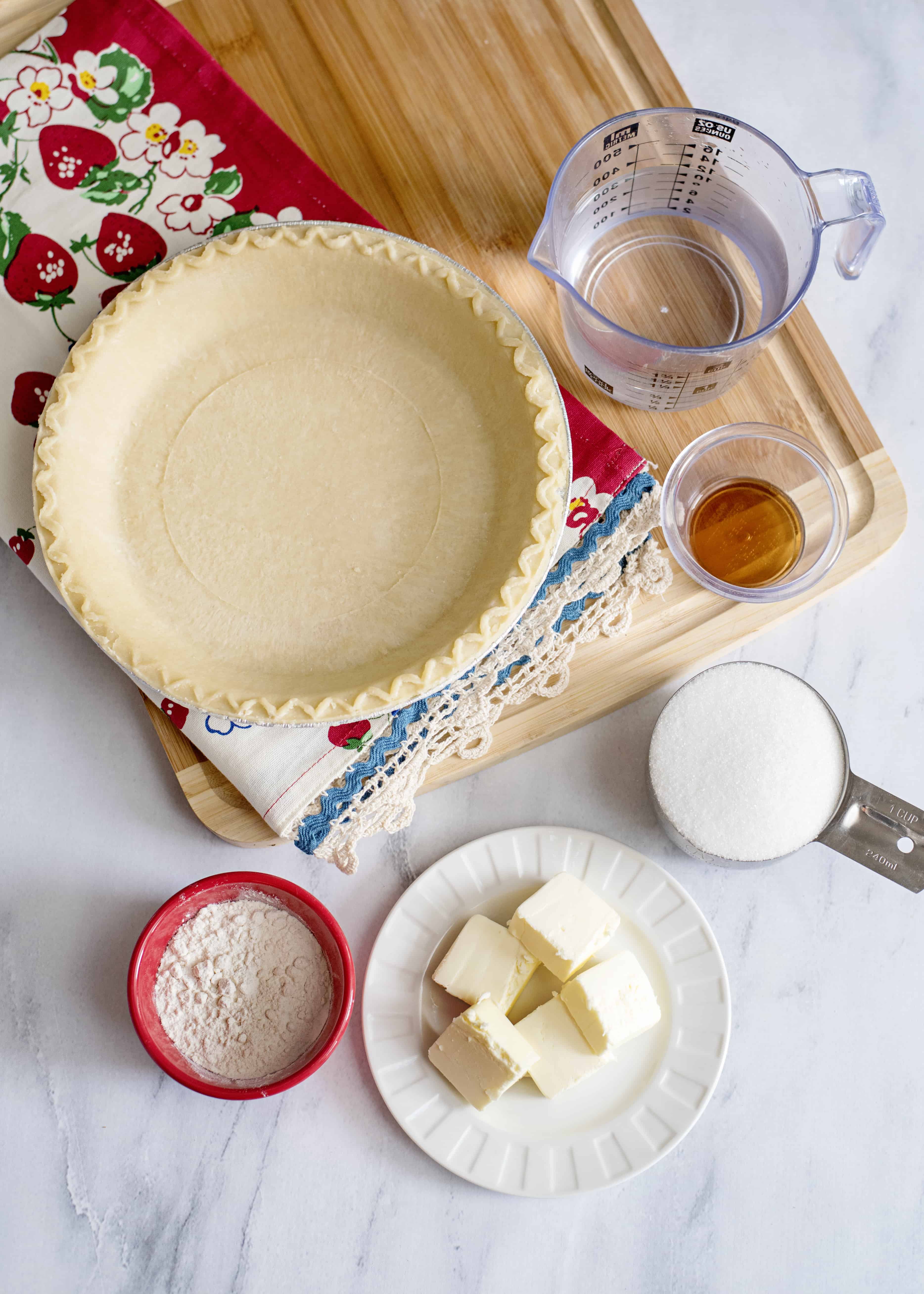 Ingredients for water pie, featuring deep dish pie crust, water, sugar, flour, butter, and vanilla extract.