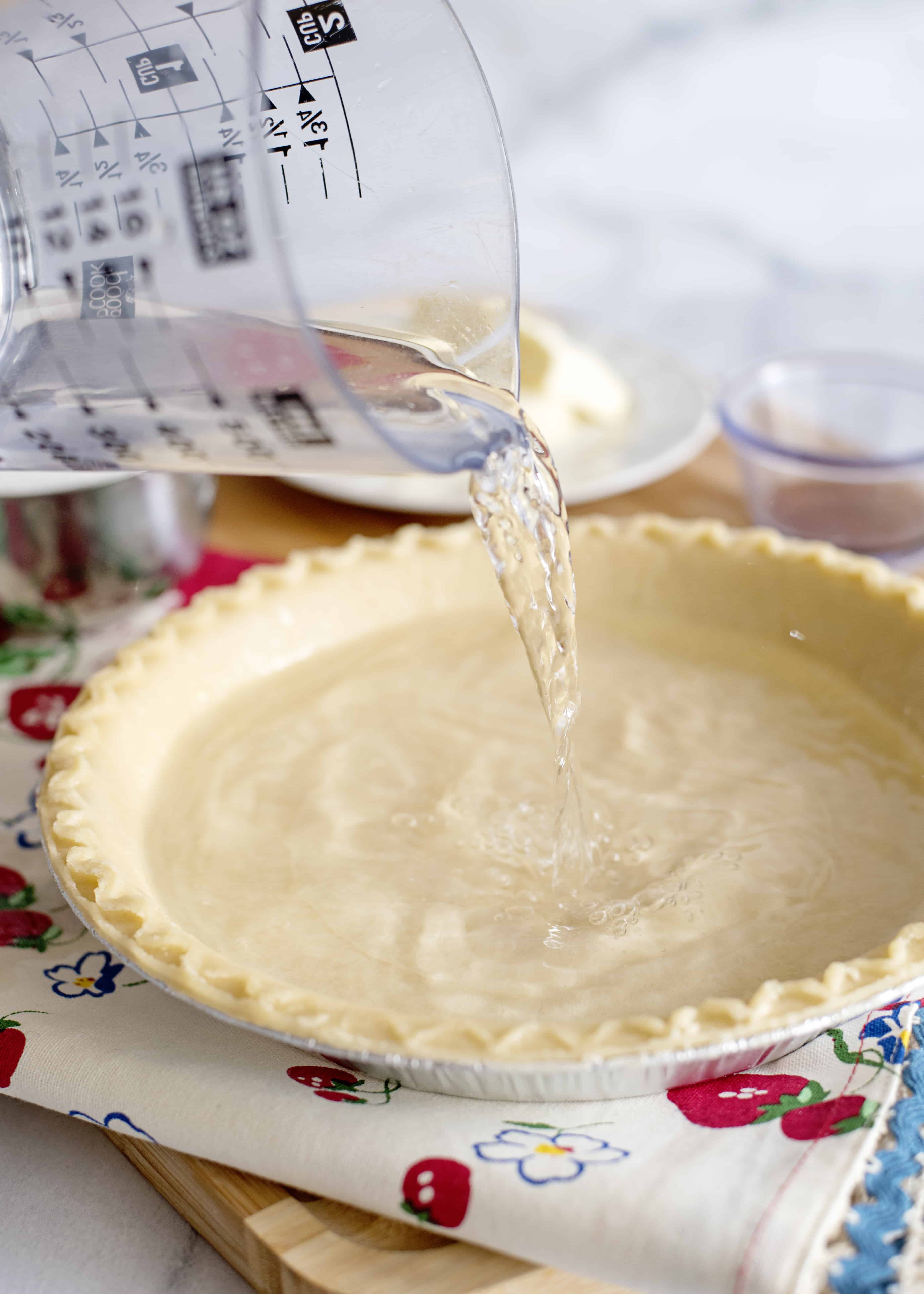 Pouring water in a pie shell.