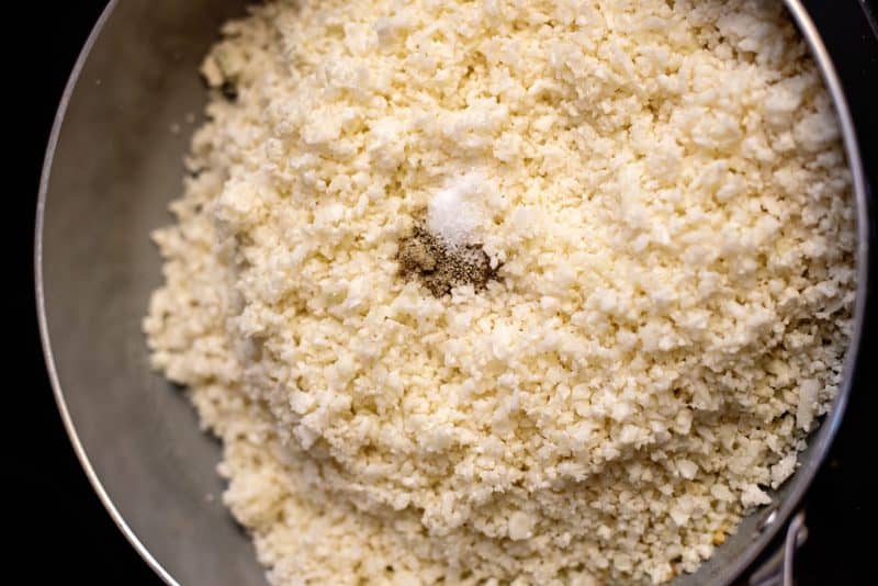 Add cauliflower, salt, and pepper to skillet.