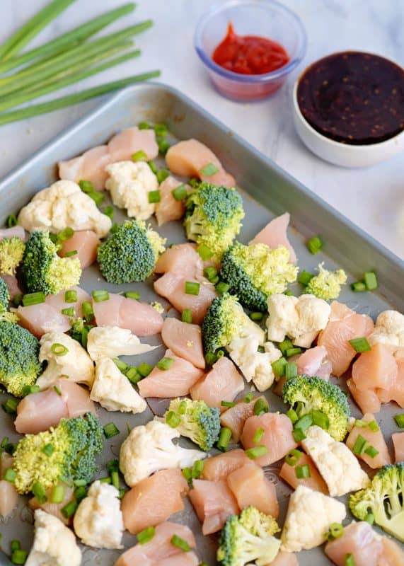 Arrange chicken and veggies on greased baking sheet.
