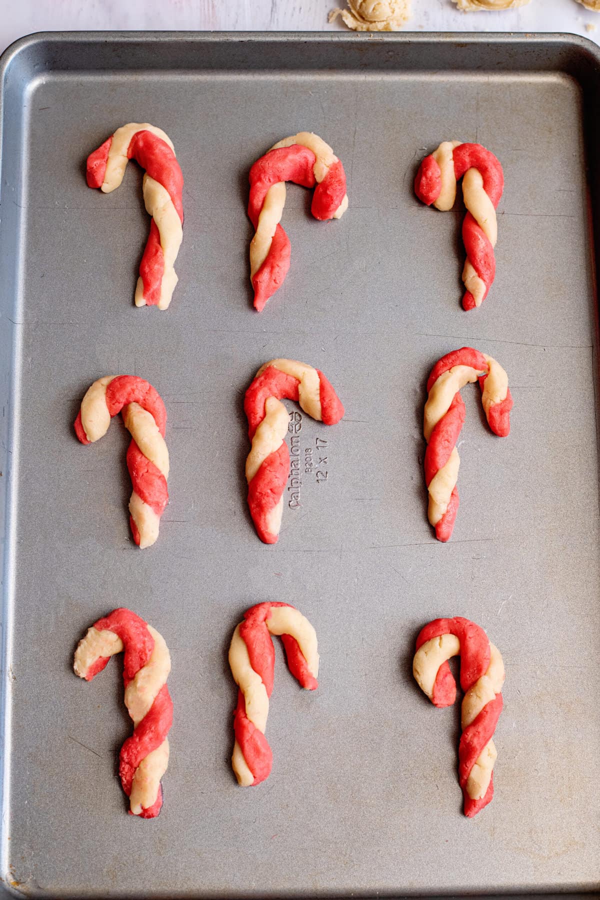 place candy cane cookies onto uncreased cookie sheet