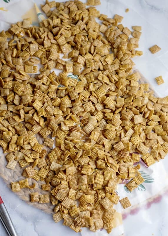 Sweet Chex mix cooling on parchment paper.