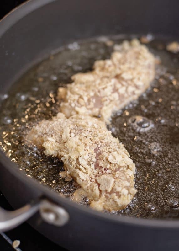 Cook breaded chicken in hot oil until golden brown on both sides.