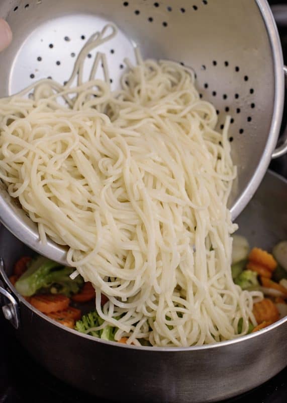 Adding noodles to skillet.