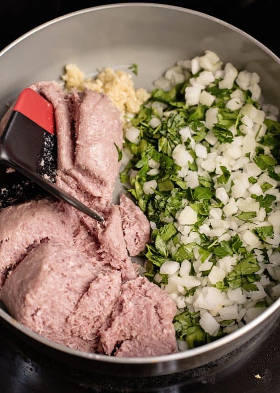 Add sausage, veggies, herbs, and garlic to skillet.