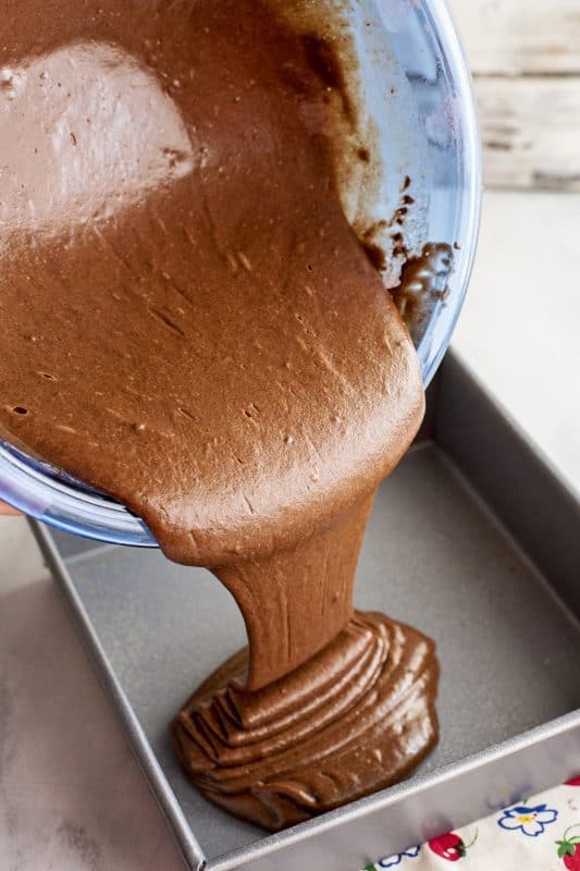 Pour chocolate cake batter into cake pan.