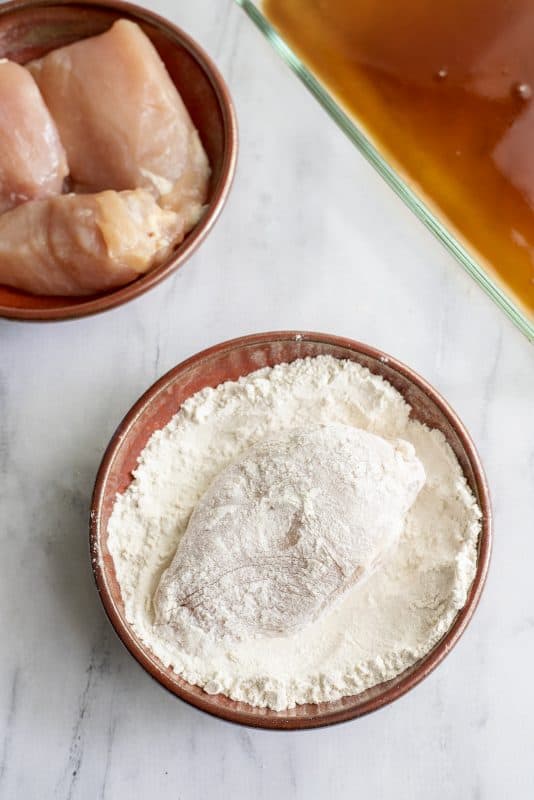 Coat chicken breast in flour.