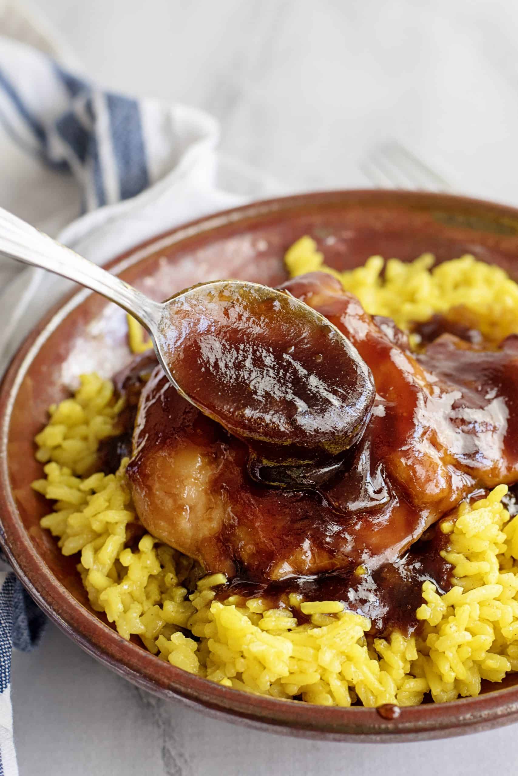 BBQ chicken breast served with yellow rice.