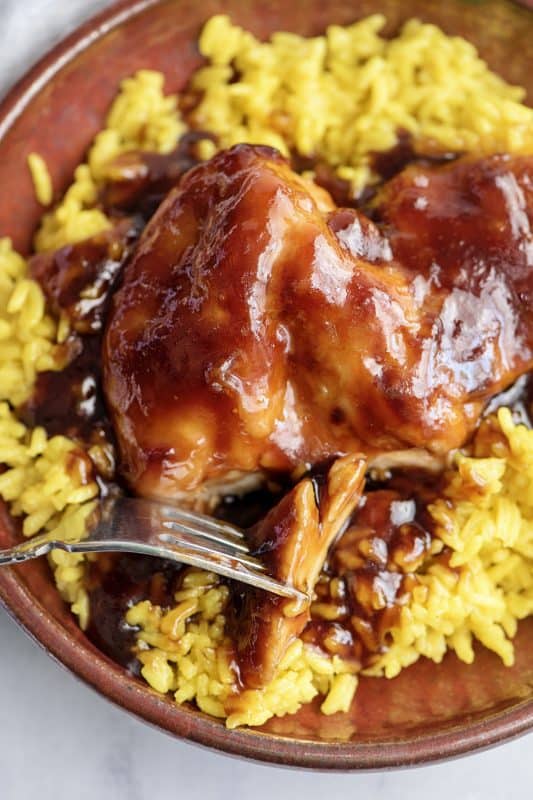 BBQ chicken breast served with yellow rice.