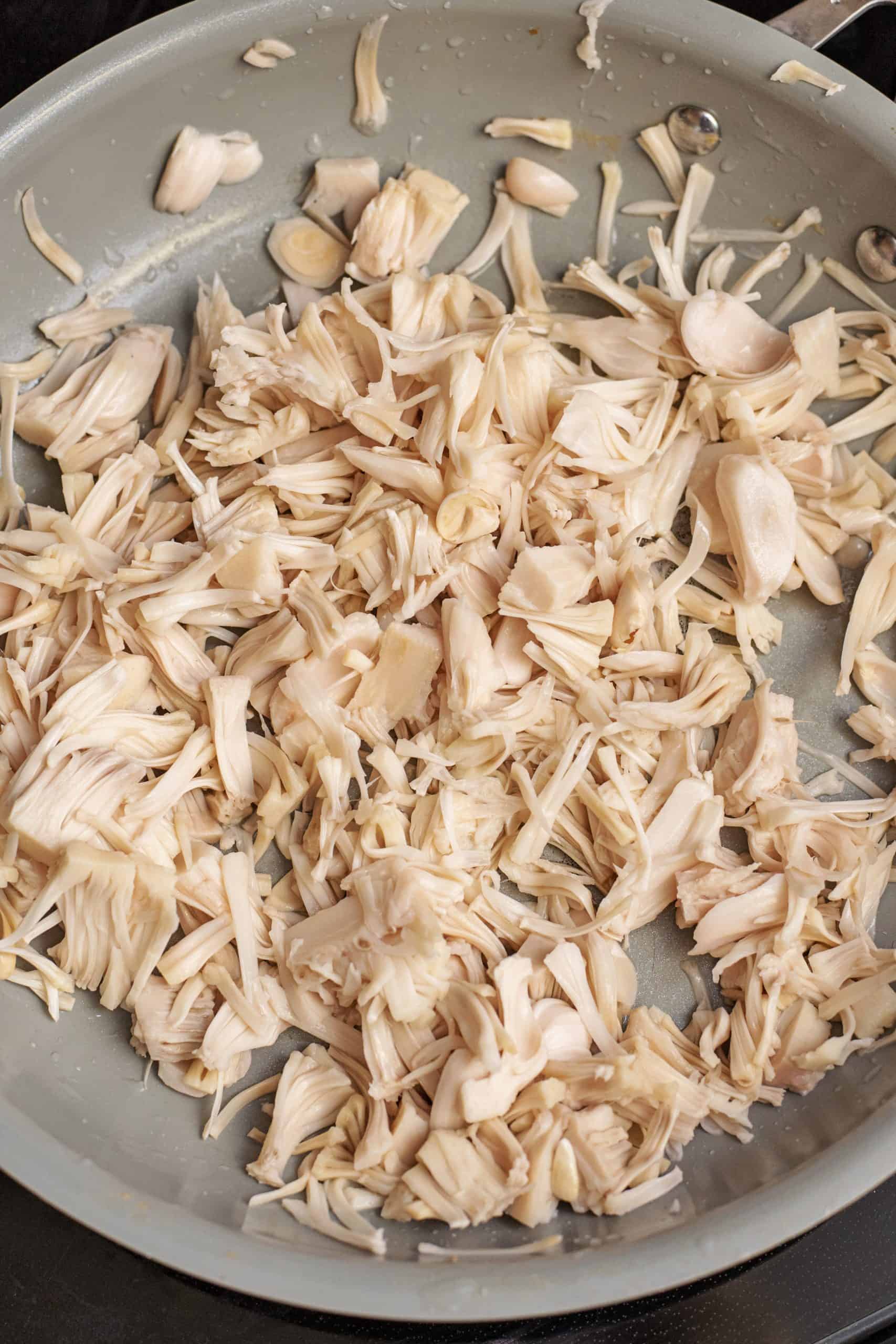 Shredded jackfruit in a skillet.