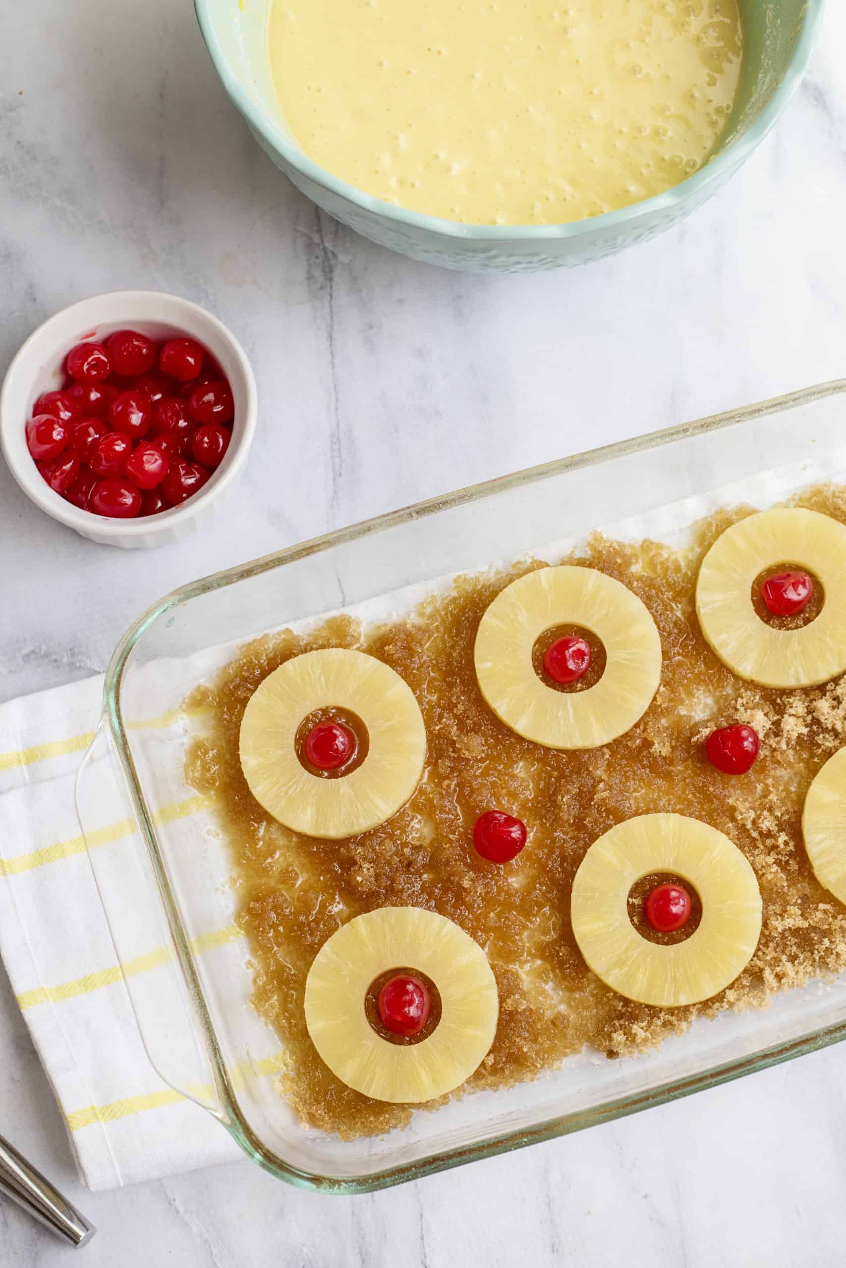 Add pineapple slices to sugar and place cherry in each center.