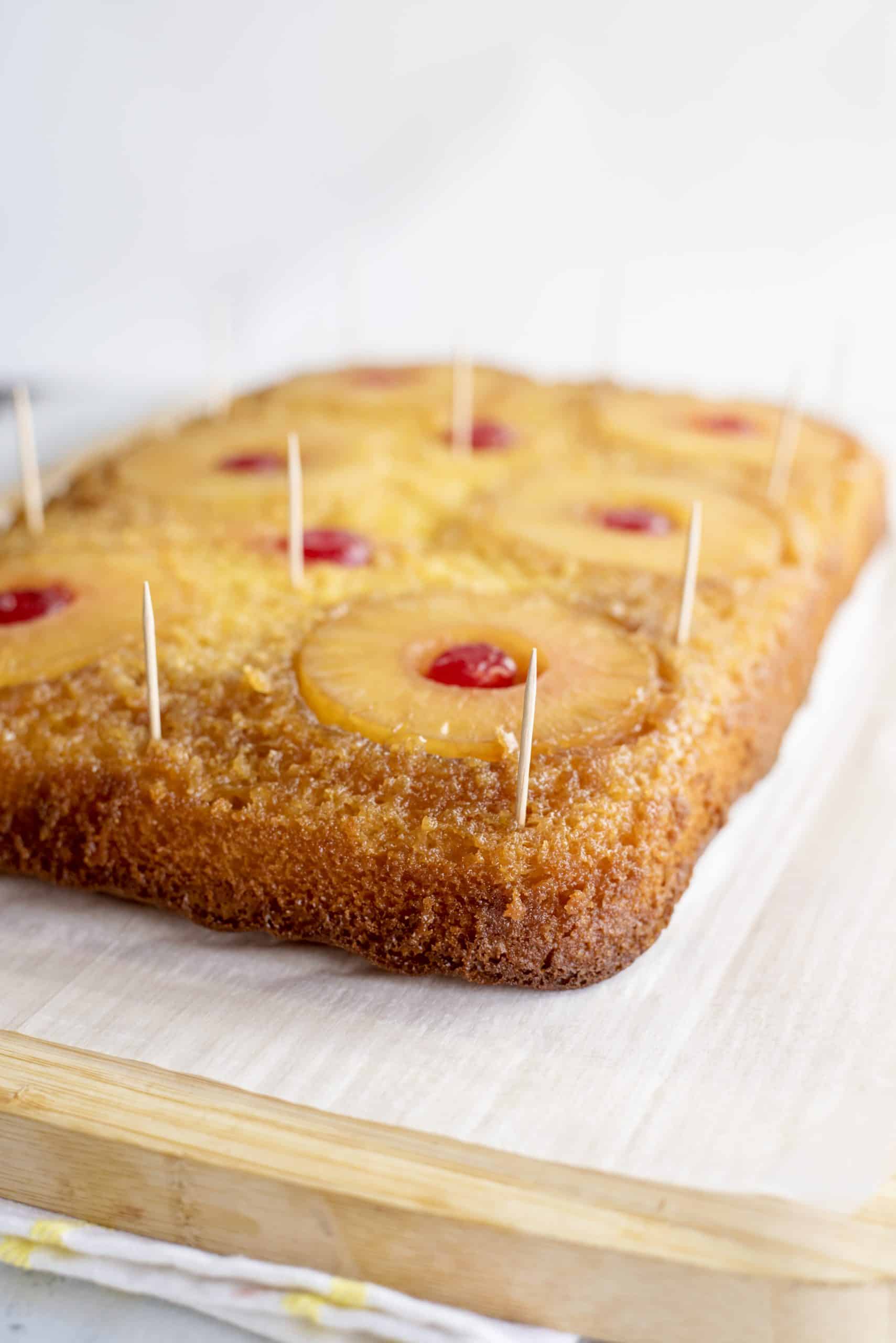 Toothpicks sticking out of a sheet of pineapple upside-down cake.