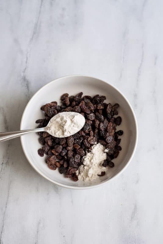 Sprinkle raisins with tablespoon of flour.