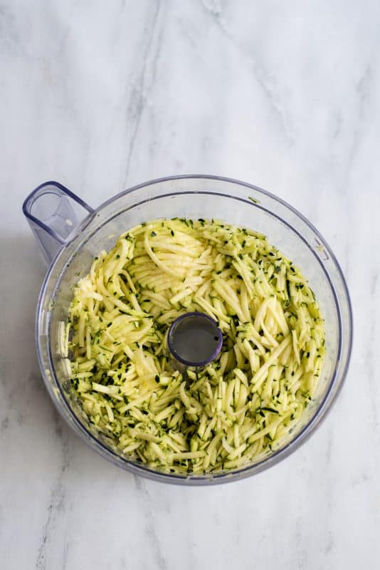 Shred zucchini using food processor.