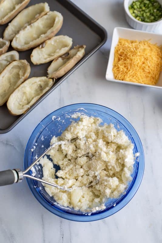 Mash filling with potato masher.