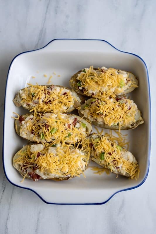 Twice-baking loaded potatoes with added cheese.