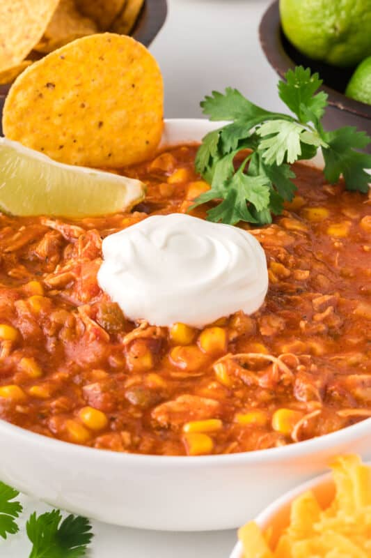 Top your chicken tortilla soup with sour cream, cilantro, and a lime wedge.