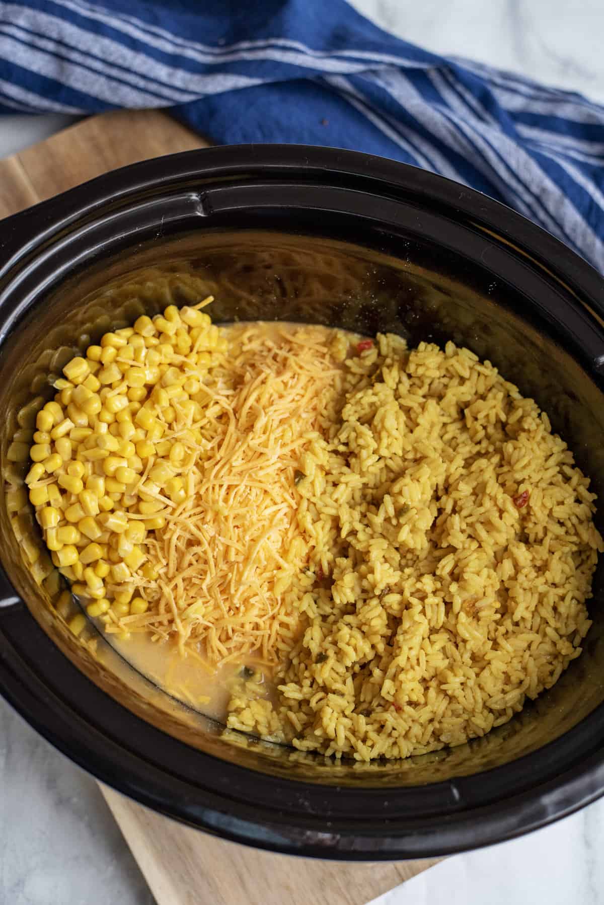 Add cheese, rice, and corn to slow cooker.