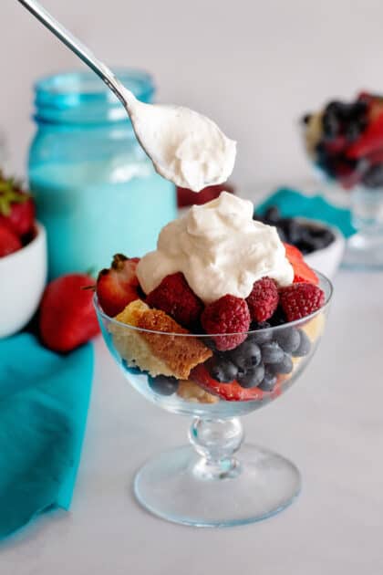 Dollop of homemade whipped cream on fruit salad.