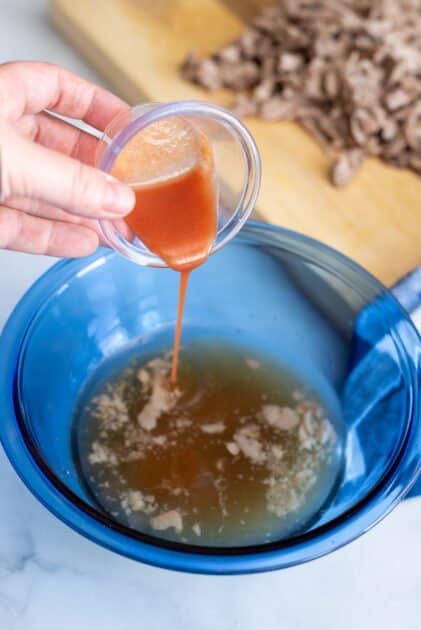 Add hot sauce to slow cooker juices in mixing bowl.