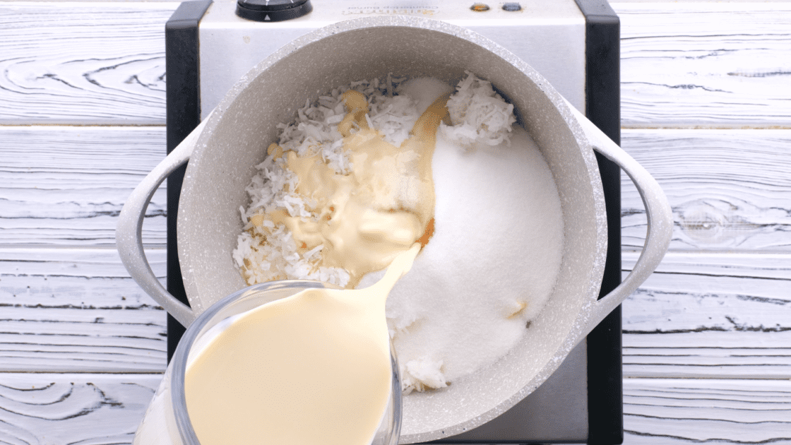 Pouring evaporated milk into saucepot.