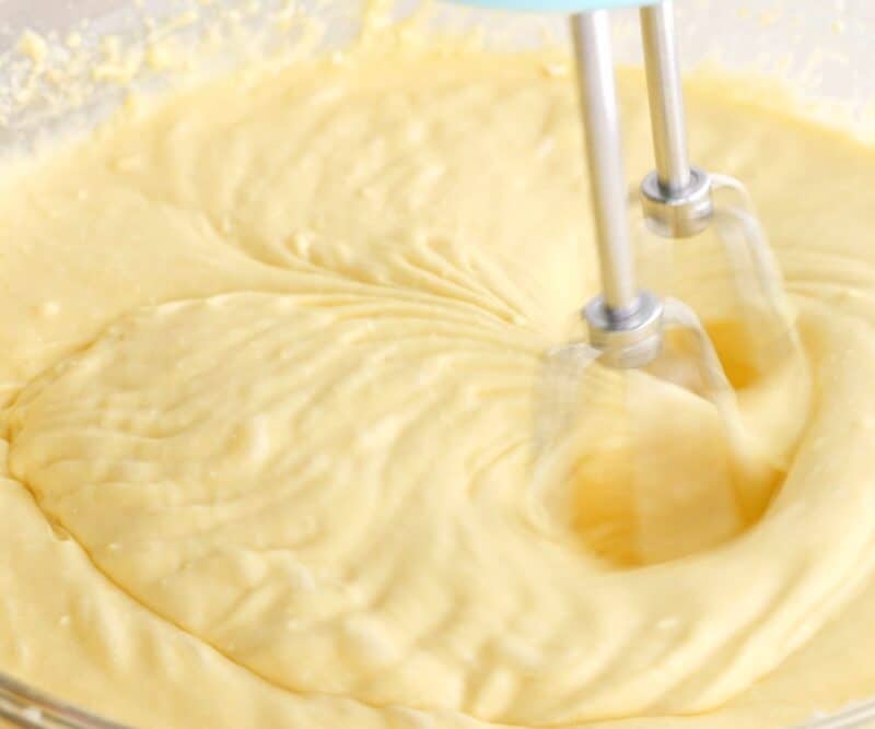 Cake ingredients being mixed with electric mixer.