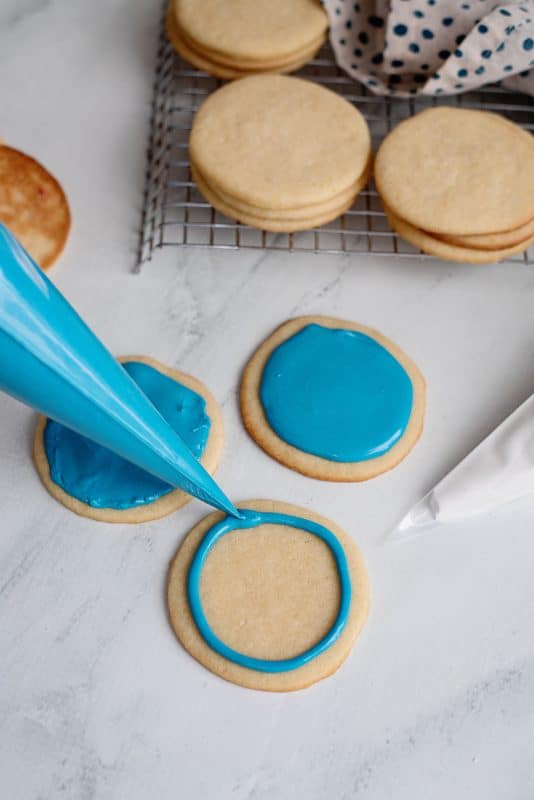 Pipe royal icing onto a sugar cookie.