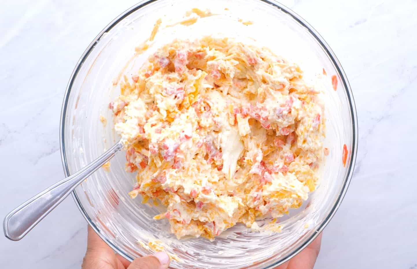 Pimento cheese spread in a glass mixing bowl.
