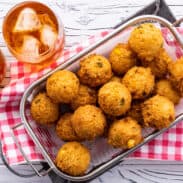 Bowl of hush puppies with glasses of sweet tea.