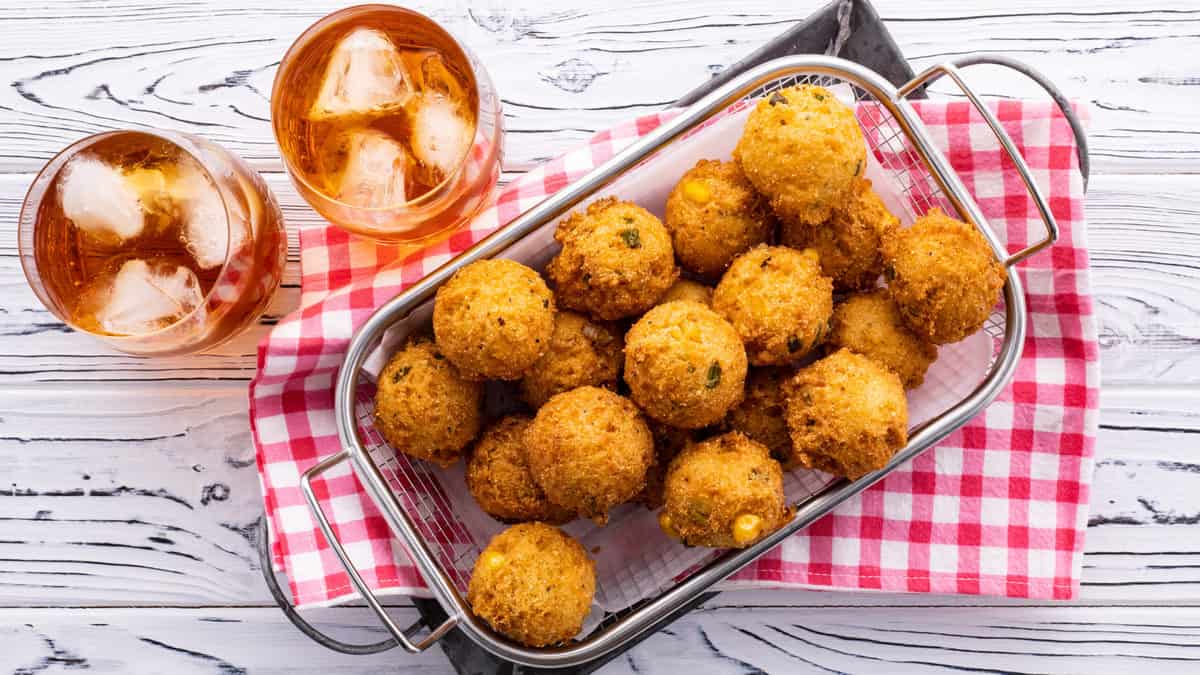 Bowl of hush puppies with glasses of sweet tea.