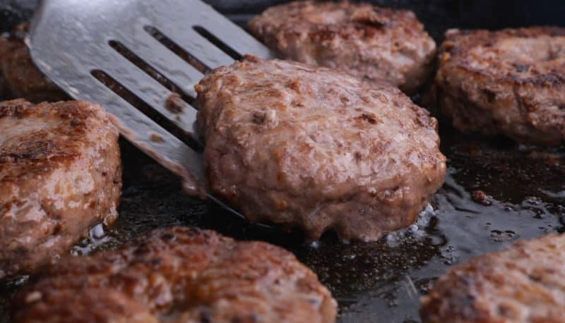 cooked hamburger steak patties frying in pan