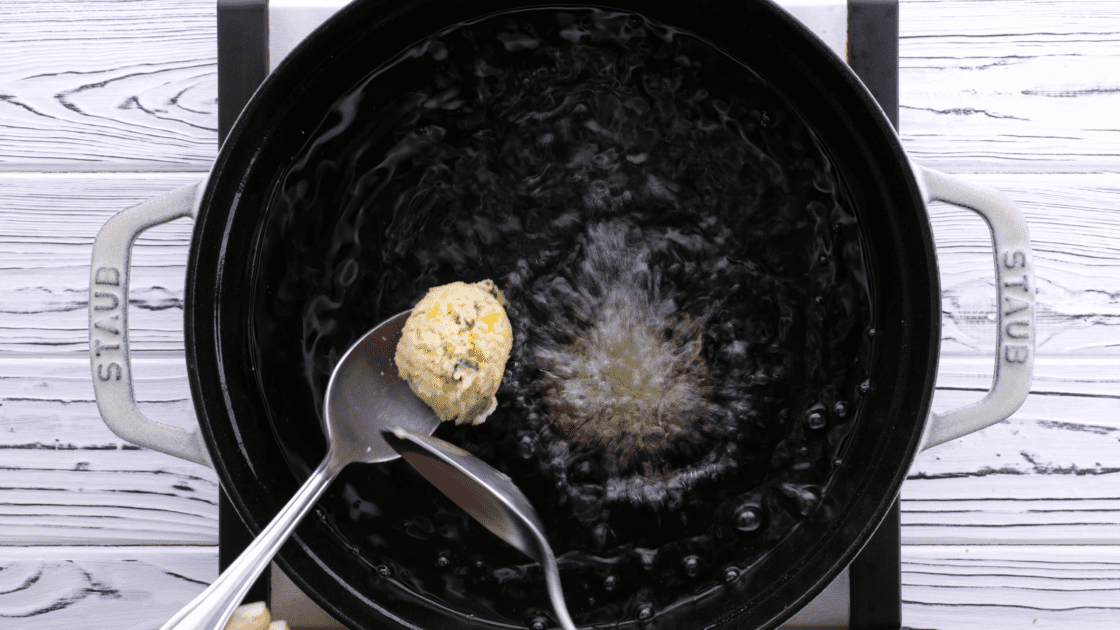 Drop spoonfuls of hush puppy batter into hot oil in saucepan.
