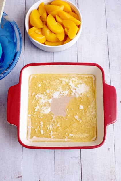 Batter on top of butter in a baking dish.