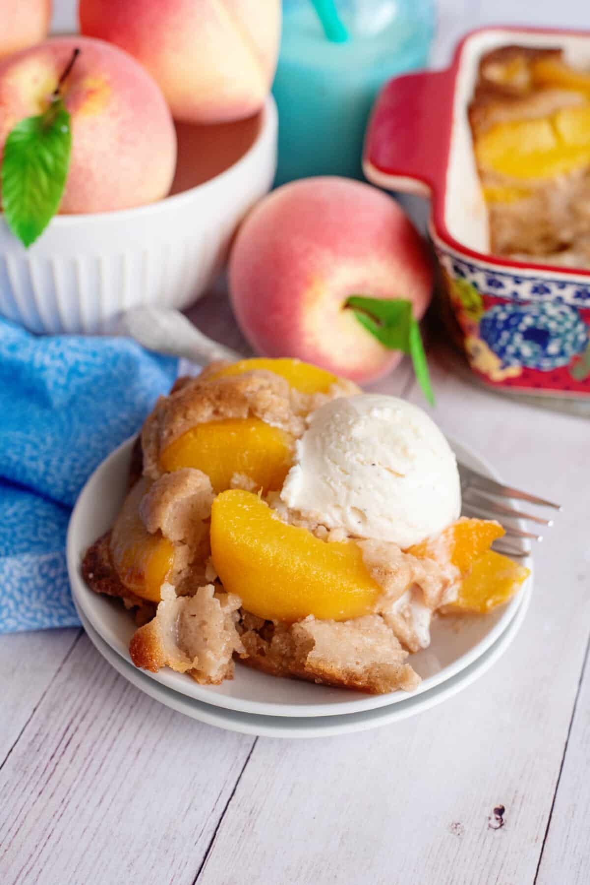 Serving of old-fashioned peach cobbler with a scoop of ice cream.