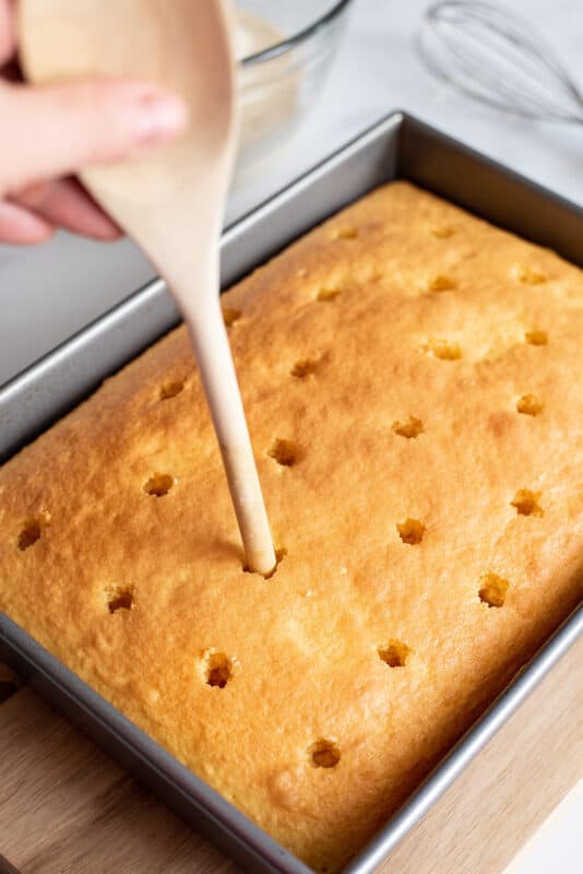 poke holes in cake with end of wooden spoon