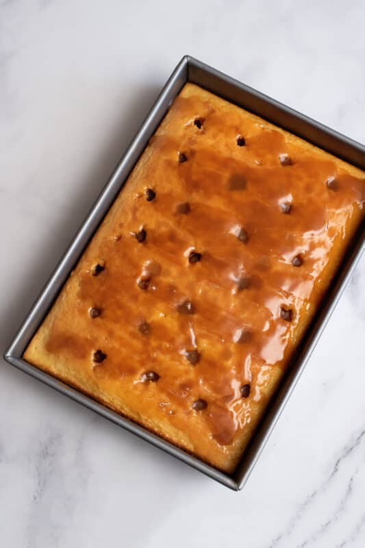 A layer of caramel spread over cuatro leches cake.