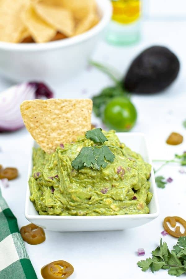 square bowl of guacamole on table