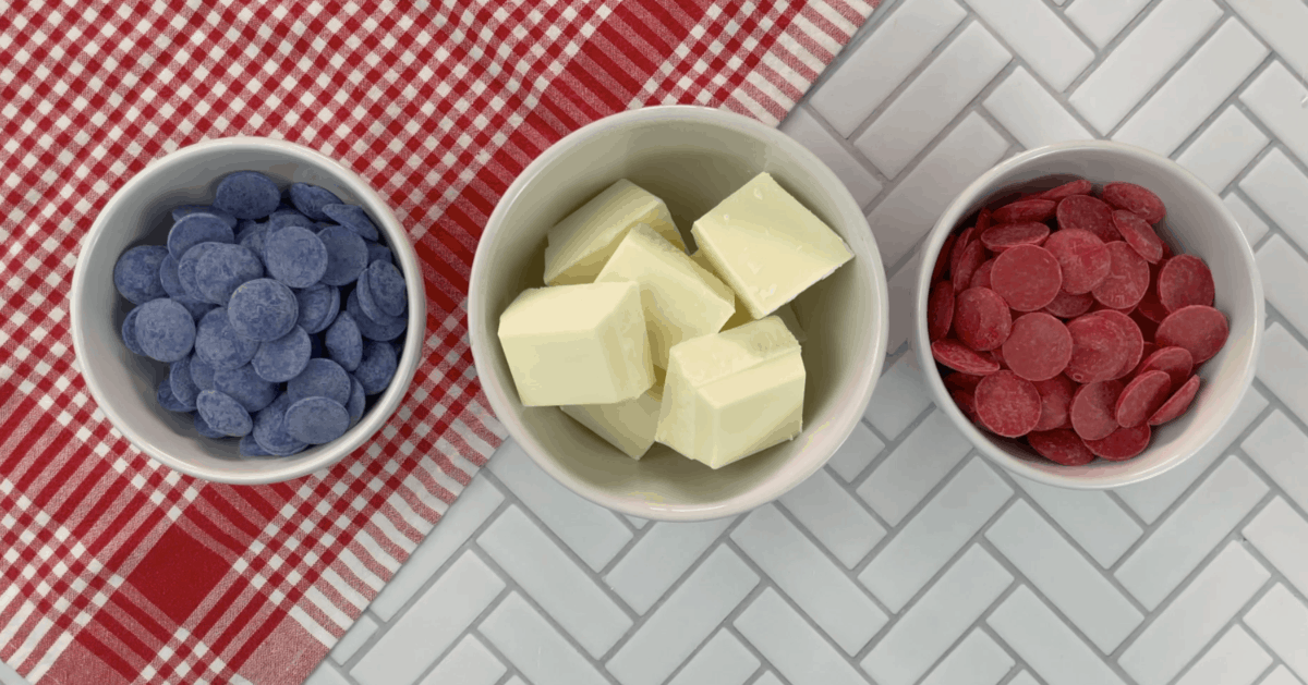 Red and blue chocolate melts with almond bark in separate bowls for Oreo balls.