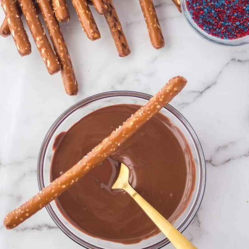 chocolate melted in bowl with pretzel sitting on top of bowl