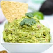 guacamole in a serving tray with chip in it